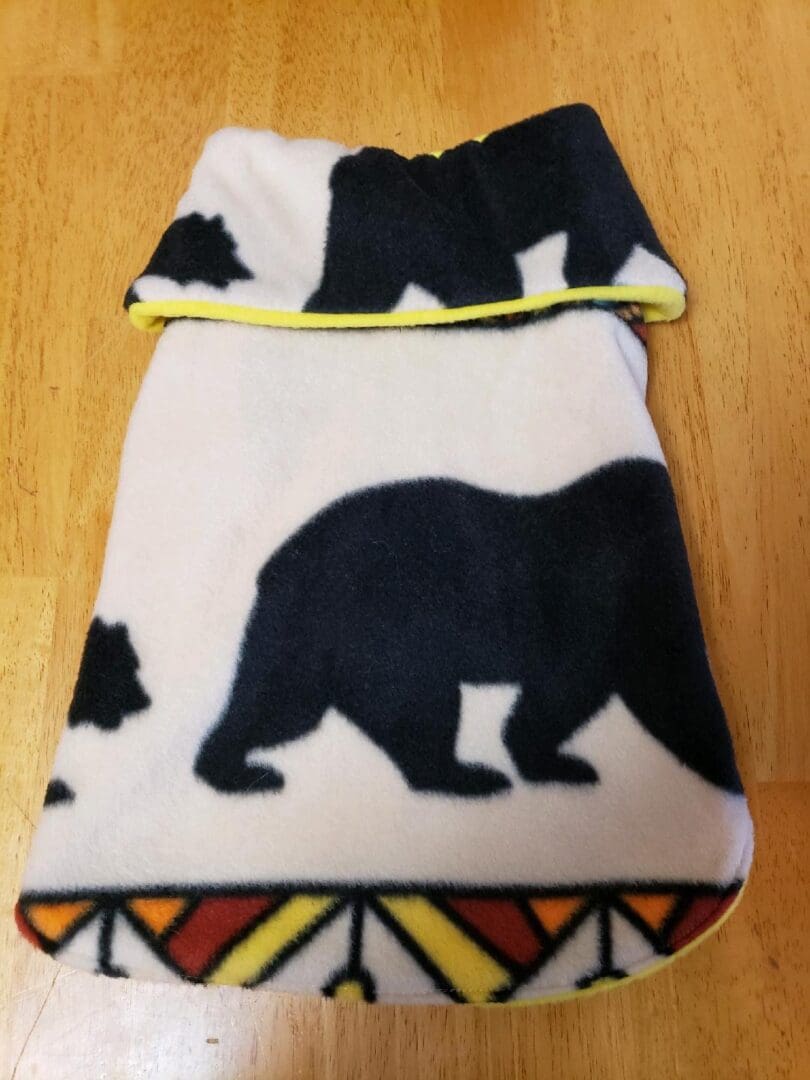 A bear blanket with a yellow trim on the bottom.