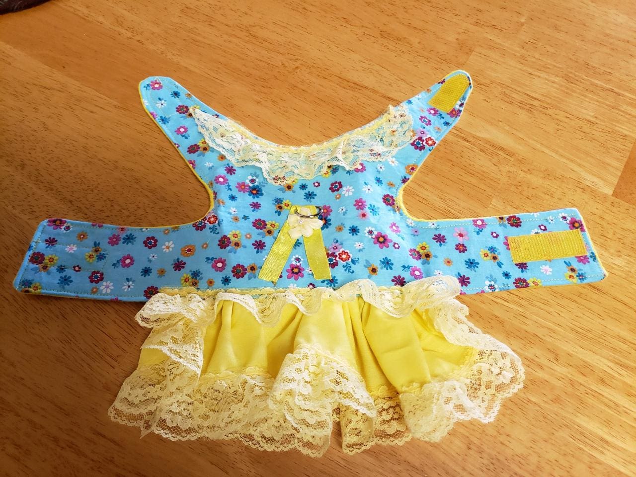 A blue and yellow dress with lace trim on the bottom.