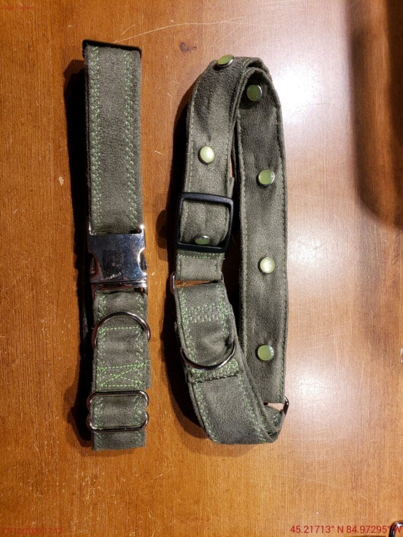 A pair of military style belts on top of a table.