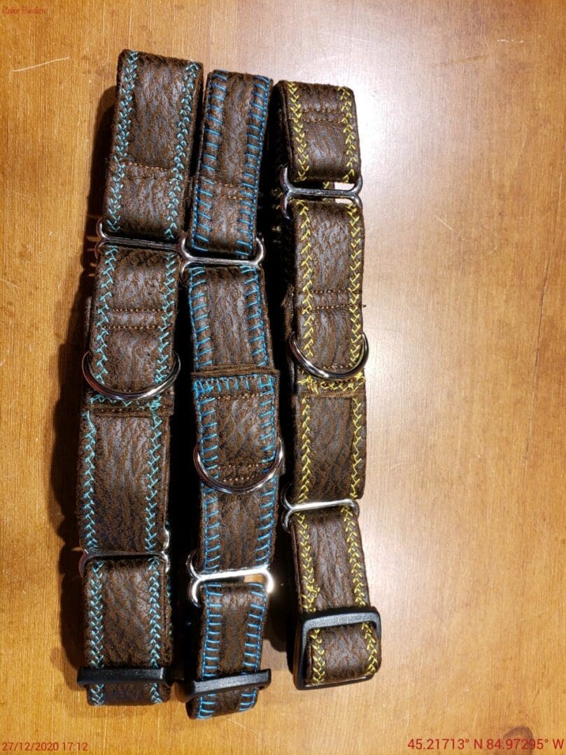 A pair of brown and blue straps on top of a wooden table.