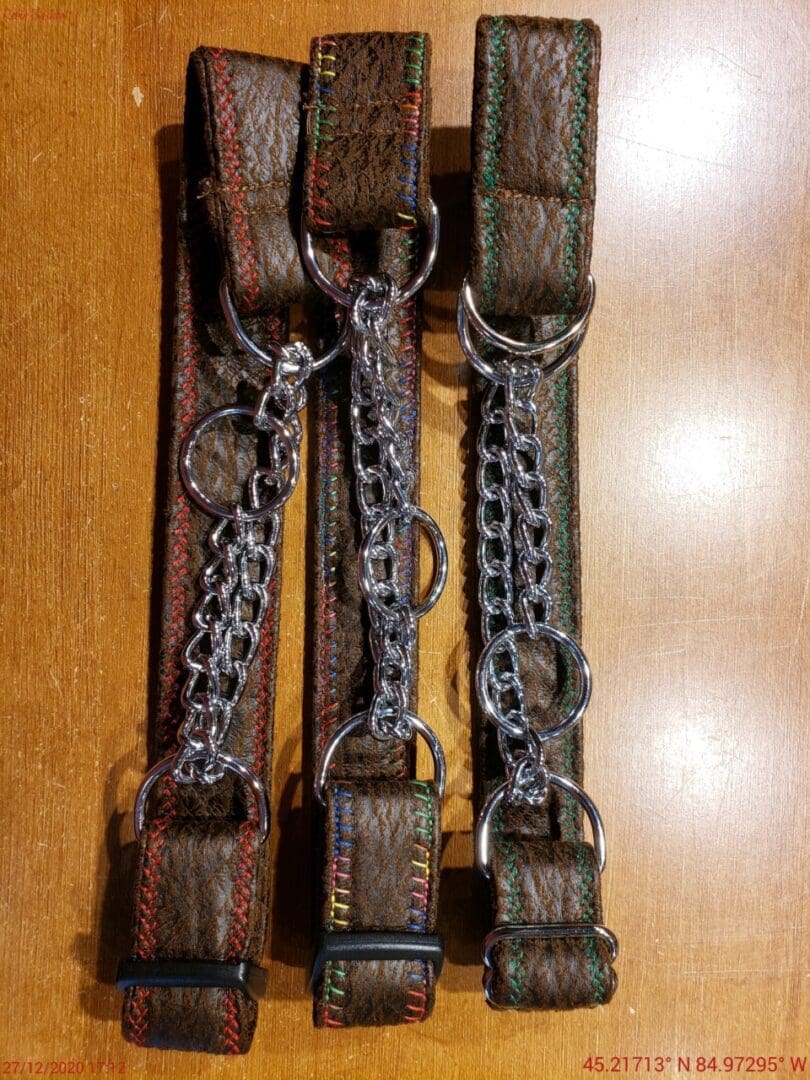 A wooden table with three pairs of chains hanging from them.