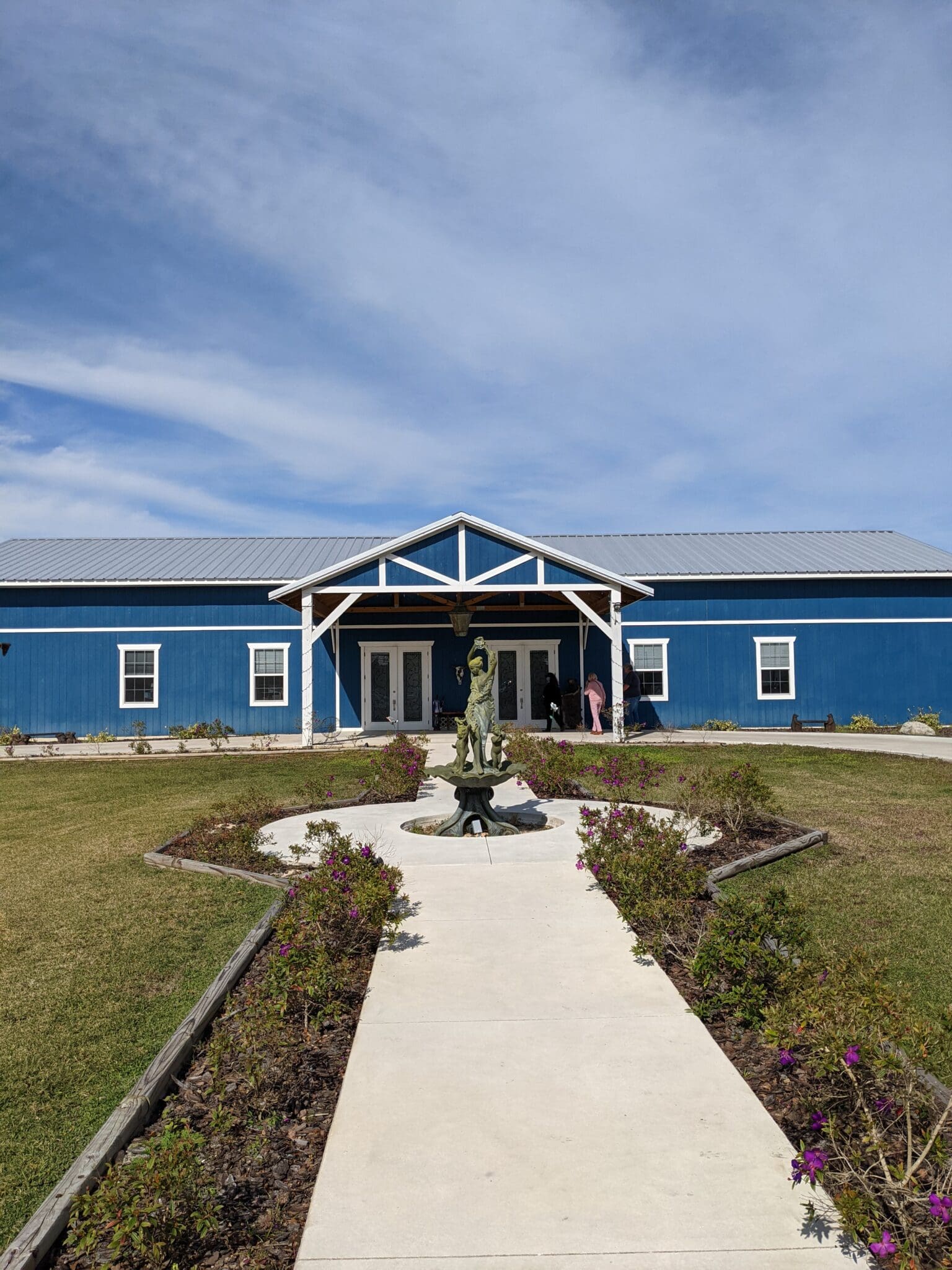 A blue building with a garden in front of it.