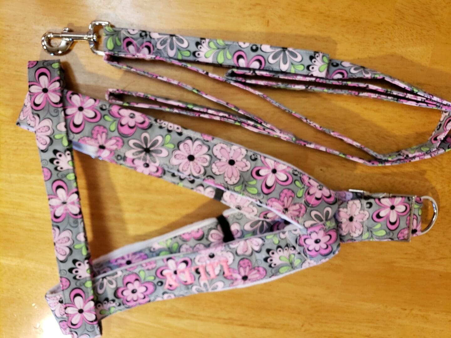 A wooden table with a pink and green floral pattern.