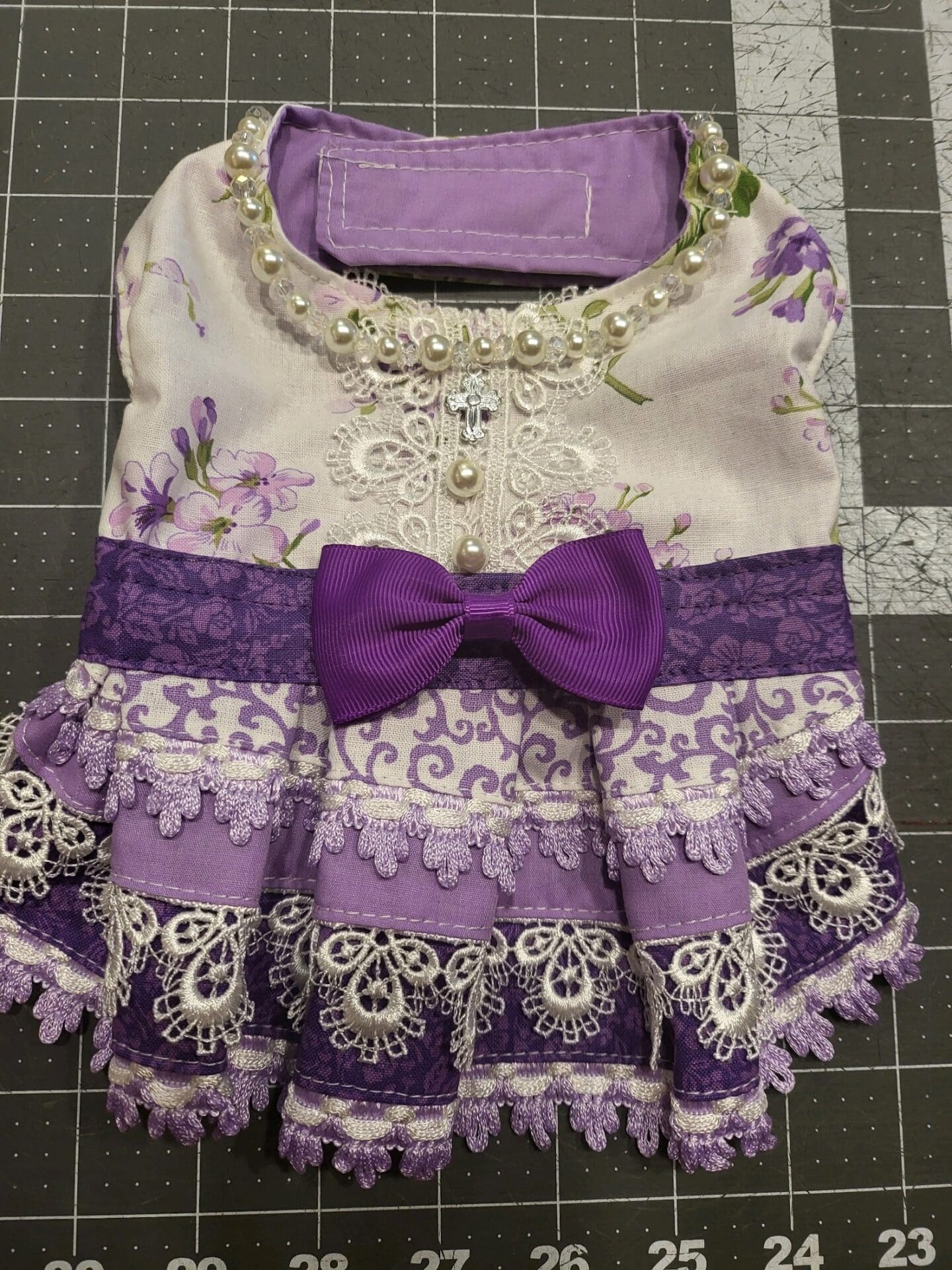 A purple dress with lace and pearls on it