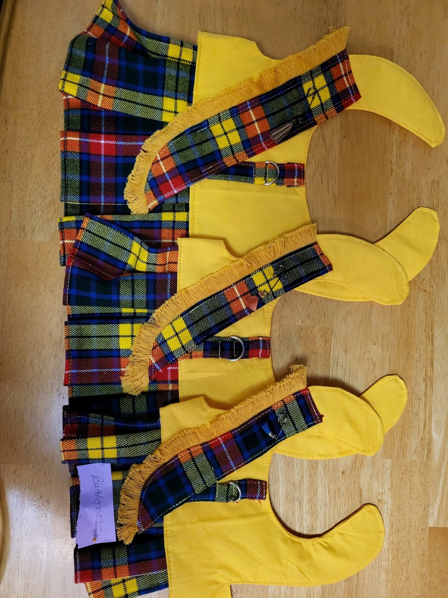 A wooden table with yellow and red plaid fabric.