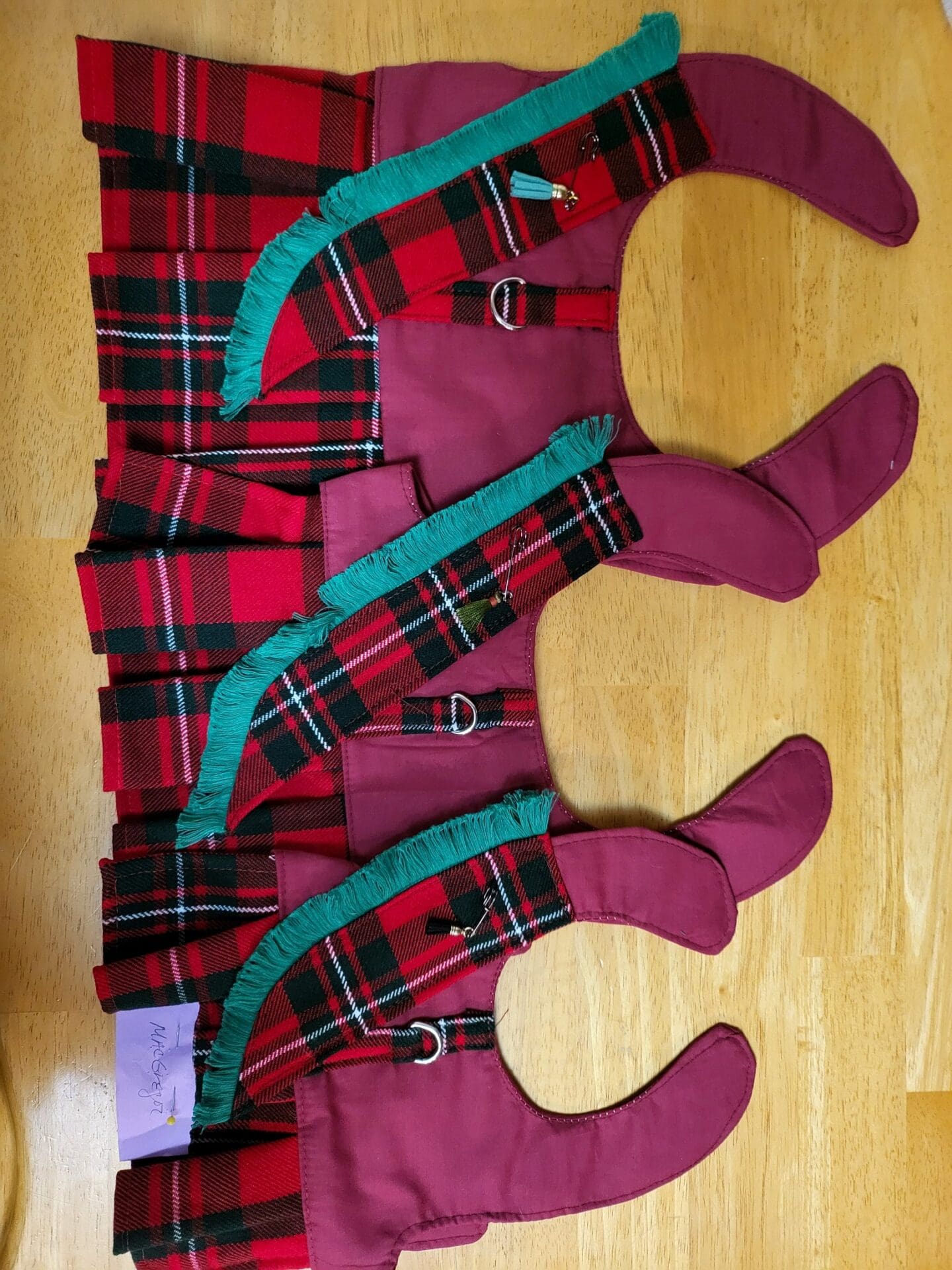 A group of red and black plaid stockings on top of a wooden table.