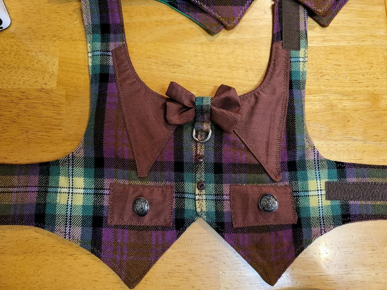 A purple plaid vest with bow tie and pocket.