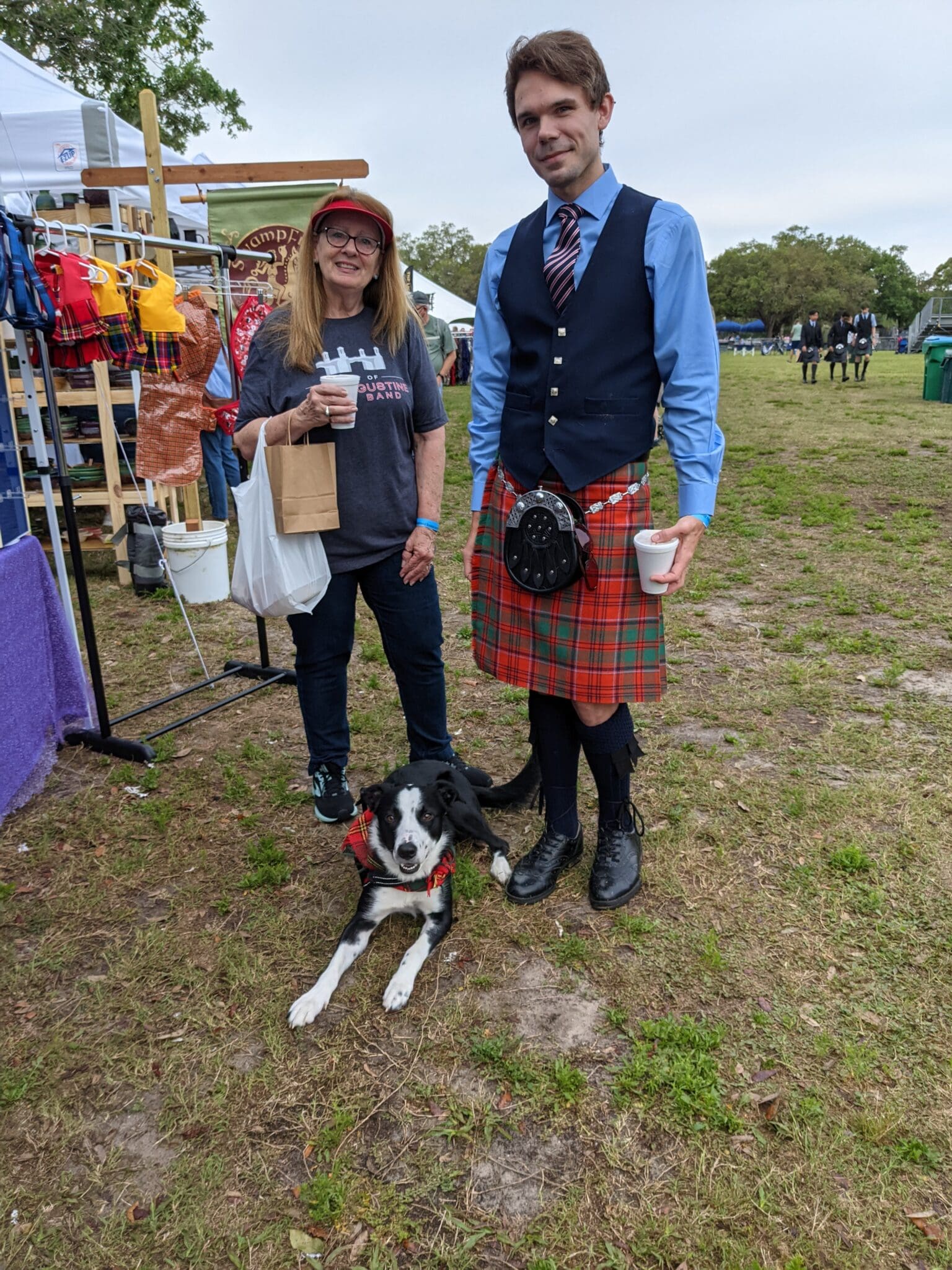 A man and woman standing next to a dog.