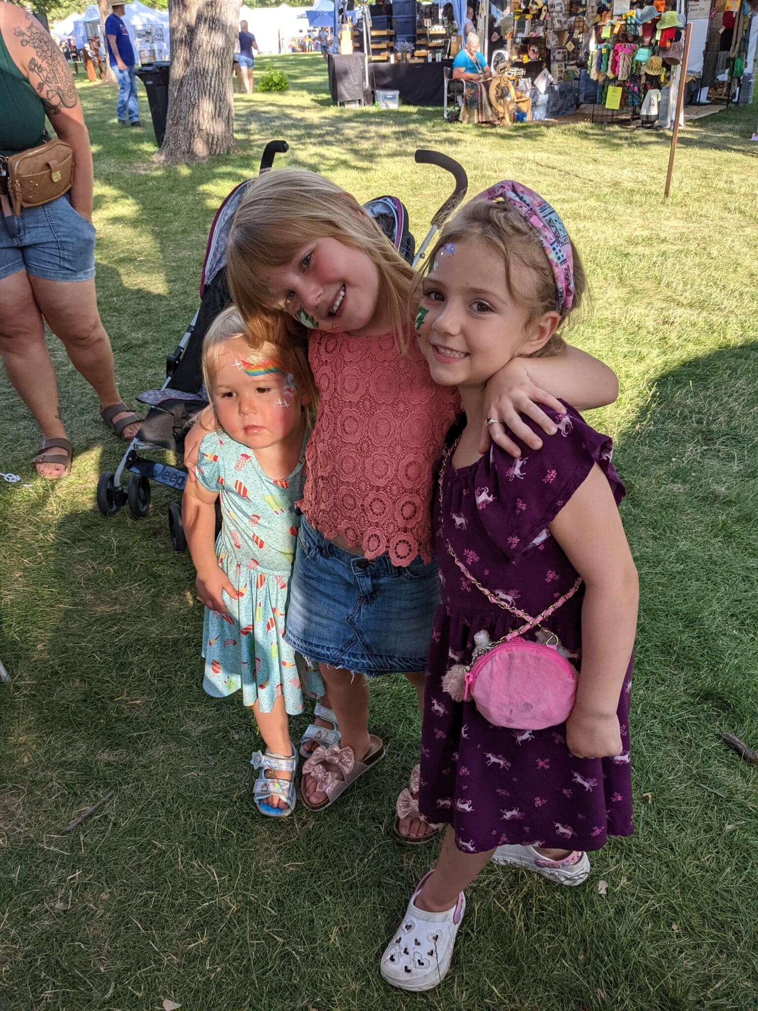 Two girls and a boy are posing for the camera.