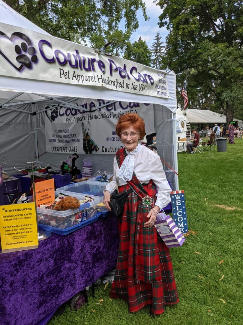 A woman in plaid skirt standing next to a tent.