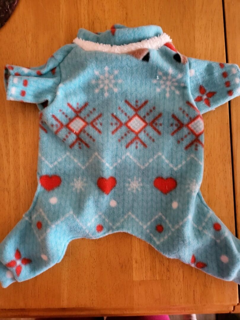 A blue and red sweater on top of a wooden table.