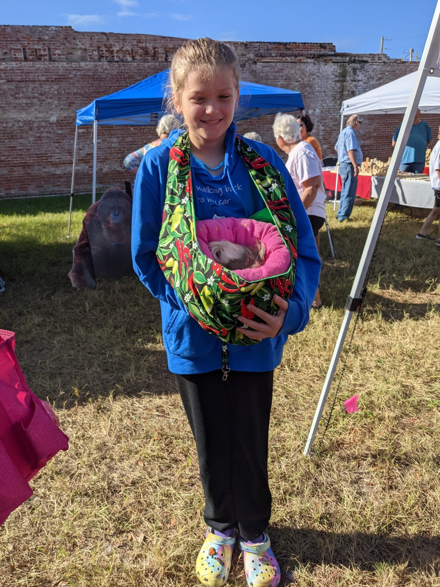 A woman holding a basket of pink flowers.