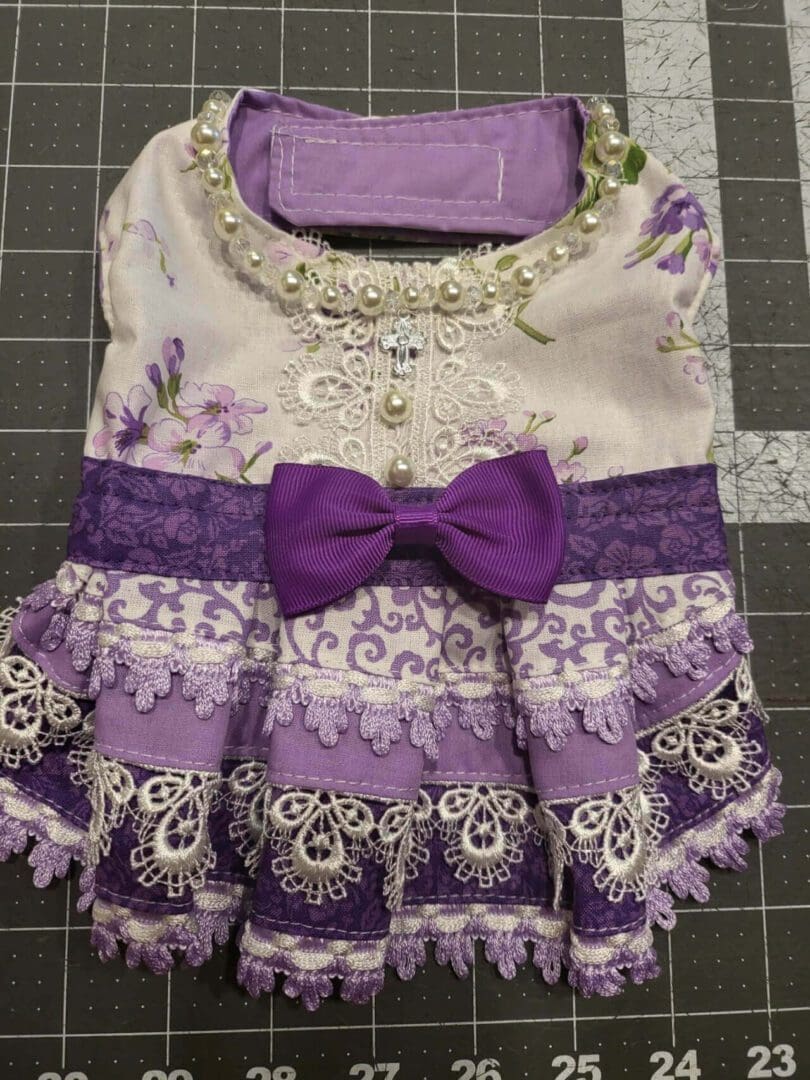 A purple dress with lace and bow on it