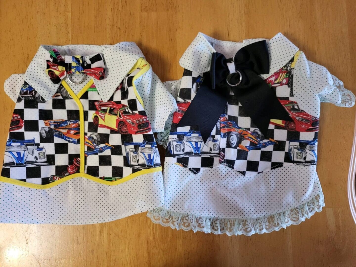 Two dog vests with cars on them and a bow tie.