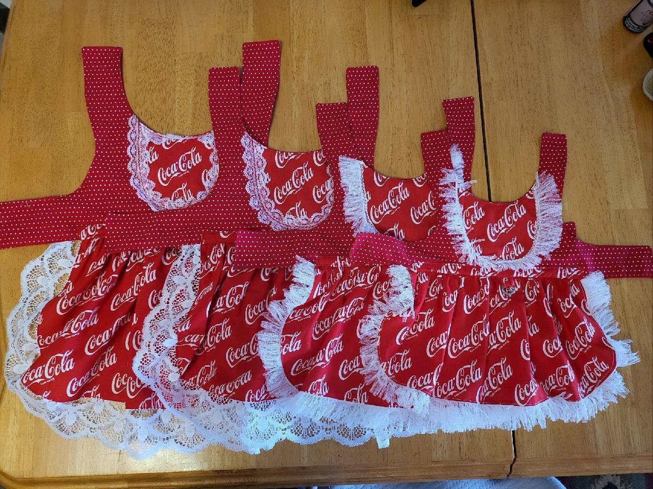 A table with several red dresses on top of it.