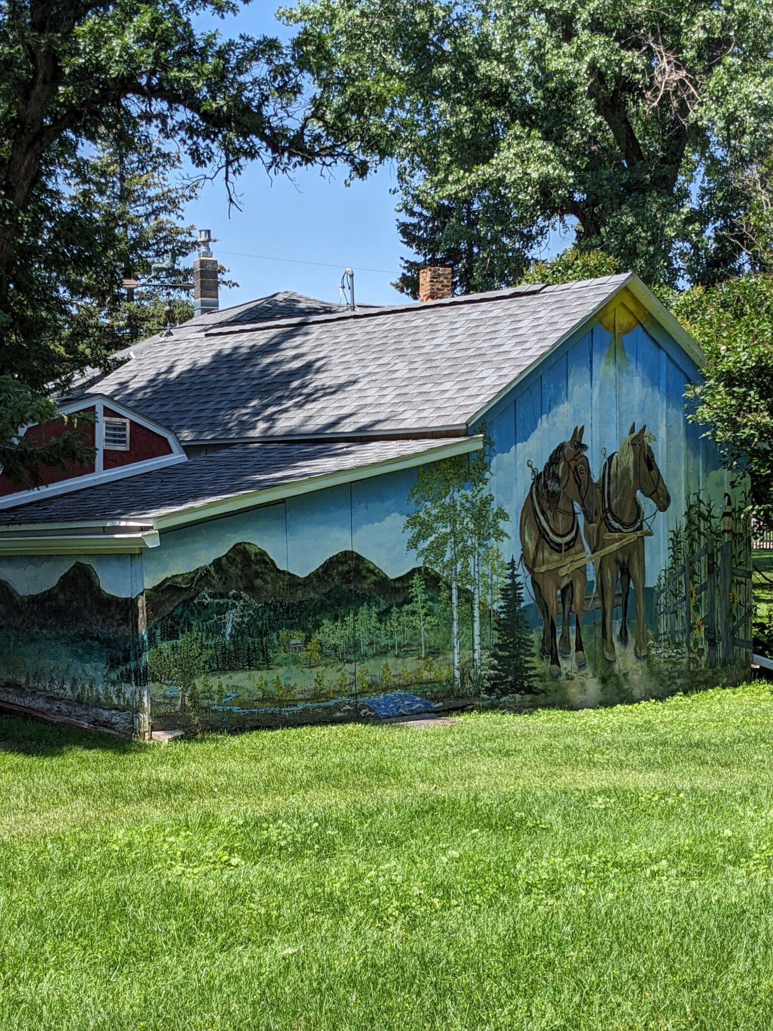 A painting of horses on the side of a house.