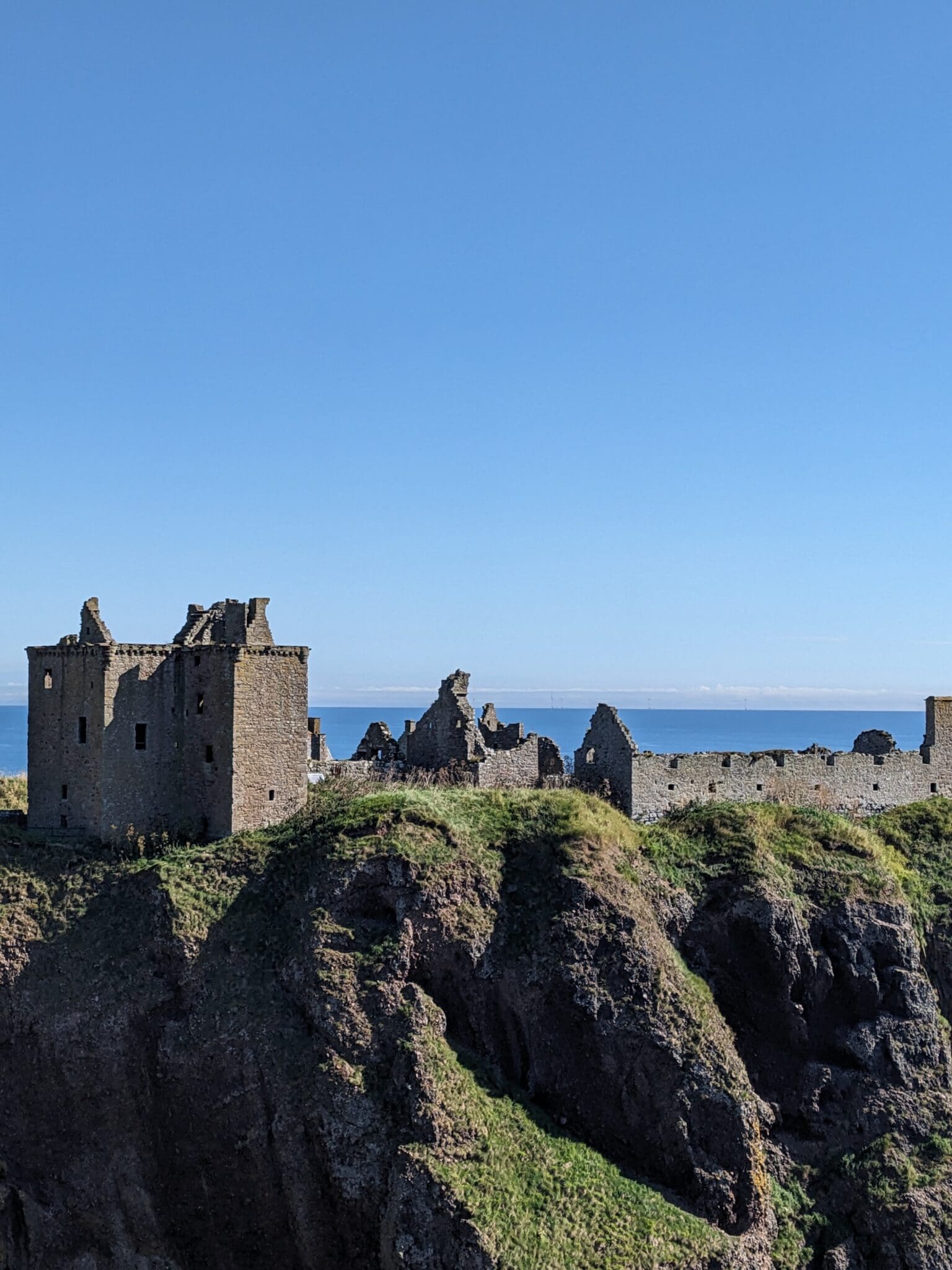 A castle on top of a hill with water in the background.