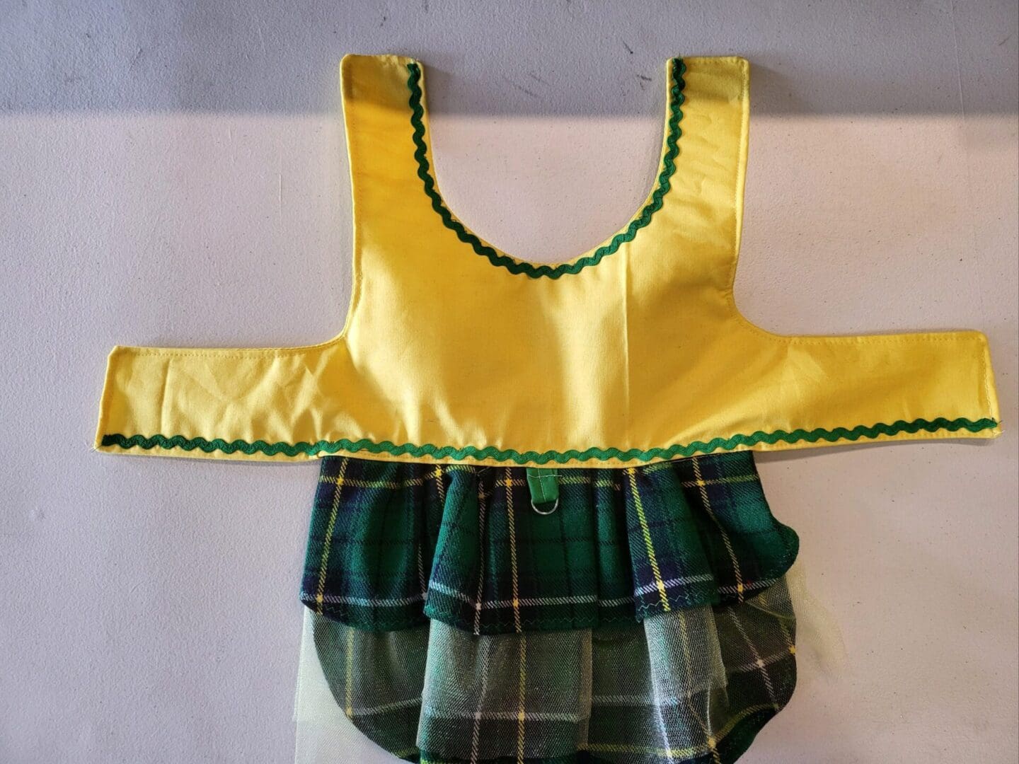 A yellow and green dress with ruffles on the bottom.