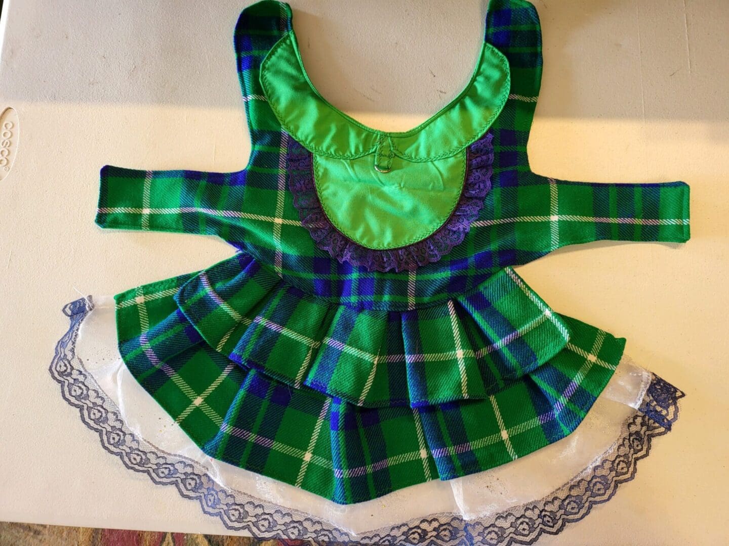 A green plaid dress is sitting on the table.