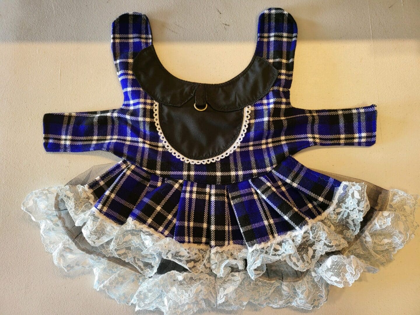 A blue plaid dress with black and white trim.